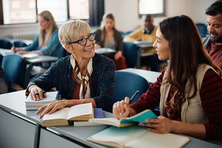 

  
      Two women talking in a classroom setting
  
